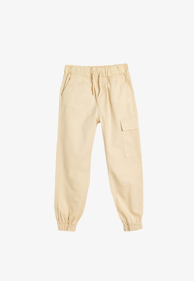 Beżowe spodnie cargo wykonane z bawełny, z elastycznym pasem, kieszeniami bocznymi oraz jedną kieszenią cargo na prawej nodze.