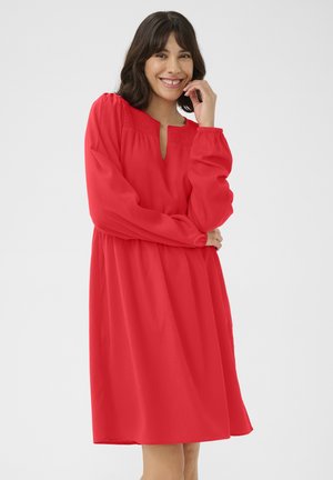 Robe rouge en tissu léger, avec des manches longues, un décolleté clé et une coupe décontractée. Texture lisse sans motifs visibles.