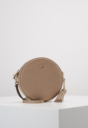 Pyöreä beige nahkainen laukku, jossa on teksturoitu pinta, kullanvärinen logo ja irrotettava hapsu. Varustettu ketju- ja nahkahihnalla monipuolista kantamista varten.