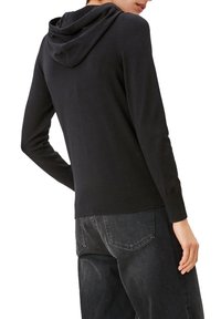 Czarny dzianinowy hoodie z długimi rękawami, ściągaczem u dołu i luźnym krojem. Teksturowany materiał o delikatnym połysku, z dekoltem z przodu i kapturem z tyłu.