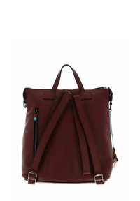 Sac à dos en cuir bordeaux avec une finition texturée, doté de deux bretelles, d'une poignée supérieure et d'une poche zippée sur le côté.