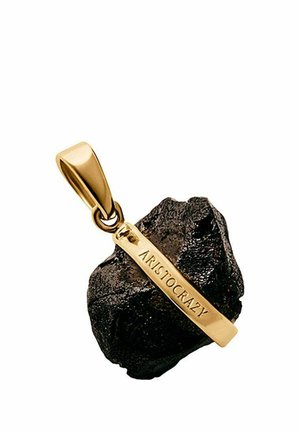 Asa de colgante en tono dorado unida a una piedra negra rugosa con una barra dorada grabada con la palabra "ARISTOCRAZY" en diagonal sobre la piedra.