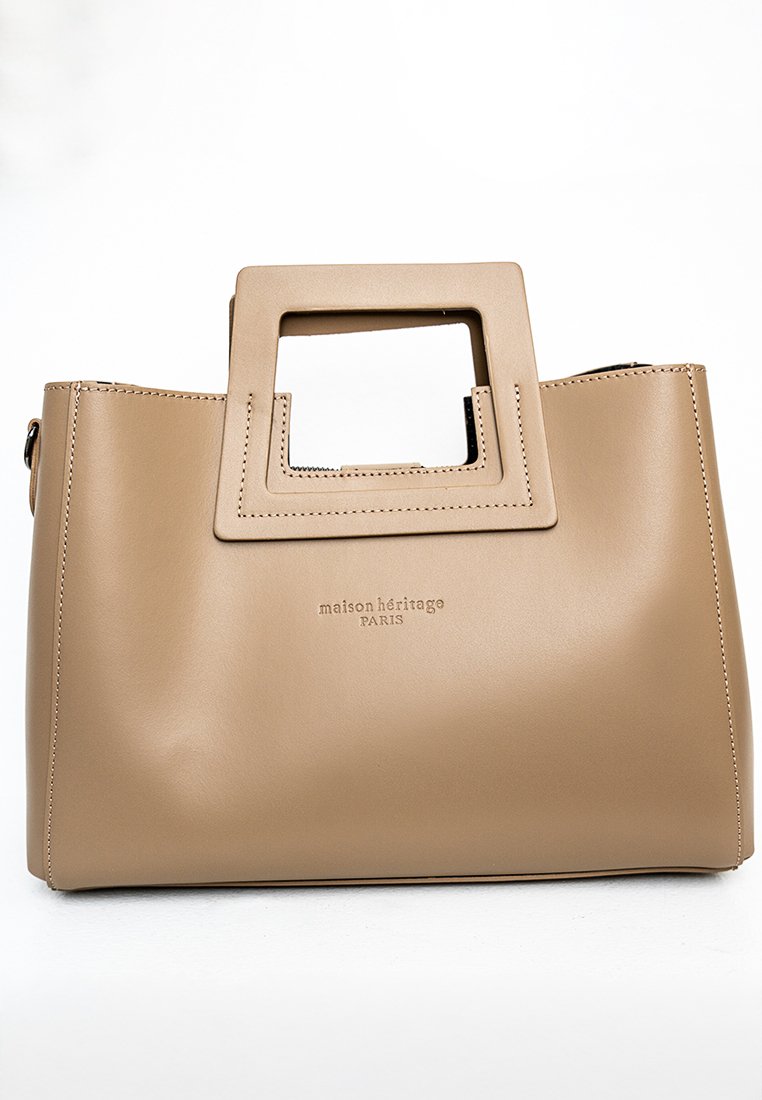 Borsa a mano in pelle beige con design strutturato, manico a forma rettangolare intagliato, logo impresso e linee pulite. Texture liscia con minimal stitching.