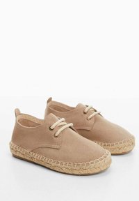 Light beige shoes with a soft suede texture, rounded toe, and lace-up design. Features a woven jute sole for added grip and style.