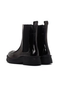 Bottines noires en cuir avec des panneaux latéraux élastiques et une semelle en caoutchouc noir texturé ; finition lisse et design à bout rond.