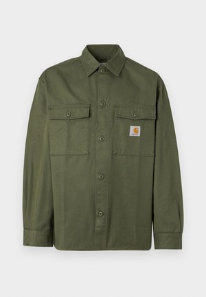 Chemise vert olive en tissu de coton, dotée d'un devant à boutons, de deux poches à rabat et d'un écusson logo sur la poitrine gauche.