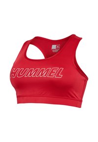Rode sportbeha met de tekst "HUMMEL" aan de voorkant, racerback-design en label binnenin met informatie over trainingsbenodigdheden en stoftechnologie.