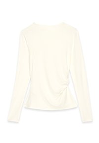 Long-sleeve cream top with a rounded neckline and gathered detail at the back waist. Soft fabric with smooth texture, fitted shape.