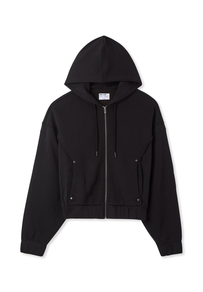 Hoodie nero corto con zip, tasche frontali, cappuccio con coulisse e polsini a costine, appoggiato piatto su uno sfondo bianco.