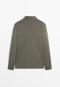 Olivgrünes langärmliges Poloshirt mit klassischem Kragen, weichem Material und eng anliegenden Bündchen. Minimalistisches Design ohne sichtbare Logos oder Muster.