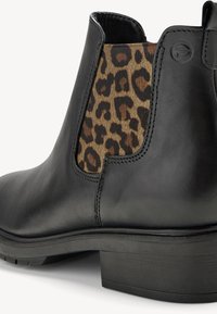 Stivale alla caviglia in pelle nera con pannello laterale elastico a stampa leopardata e tacco basso a blocco, con cuciture dettagliate sulle giunture.