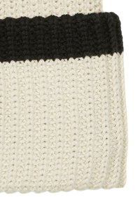 White knit beanie with a black ribbed cuff. Made of textured yarn, featuring a striped pattern. Soft, flexible material.