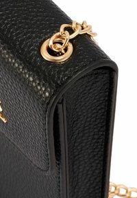 Czarna torebka z teksturowanej skóry z złotymi akcesoriami, z łańcuszkowym paskiem i eleganckim prostokątnym kształtem. Zwróć uwagę na staranne wykończenie i przeszycia.