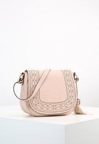 Rosa lädercrossbodyväska med perforerad detaljering, böjd form, justerbar rem och fransdetalj. Slät textur, minimal hårdvara.
