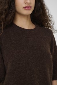 Pull en laine marron avec un col rond, des manches courtes et une surface texturée, légèrement duveteuse. Mettez l'accent sur la chaleur et la douceur du tissu.