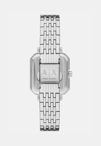 Reloj de pulsera de eslabones de metal plateado con caja rectangular y cierre grabado con el logo "A|X Armani Exchange", visto desde la parte posterior.