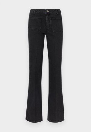 Μαύρο τζιν με φαρδιά καμπάνα και ψηλή μέση, δύο πίσω τσέπες, θηλιές για ζώνη και κούμπωμα με κουμπί και φερμουάρ μπροστά σε λευκό φόντο.