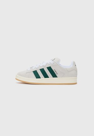Grå sued sneaker med tre grønne striper, hvite snører, såle i gummirubber og "CAMPUS" merke på siden. Klassisk lav-top design.