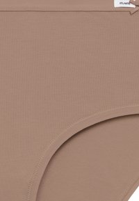 Beżowa bawełniana bielizna o gładkim wykończeniu, z szerokim pasem i bezszwowym otworem na nogę dla wygody. Mała metka przymocowana u góry.