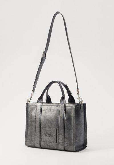 Zwarte leren handtas met structuur, dubbele handgrepen aan de bovenkant, een verstelbare schouderband, en een patch met logo-embossing aan de voorkant.