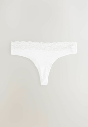 Bela tangica z lace pasom. Tkanina je mehka, z gladko teksturo. Oblikovanje je minimalistično, s poudarkom na udobju in prileganju.