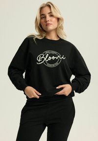Czarna bluza z długim rękawem, ściągaczami przy nadgarstkach oraz graficznym nadrukiem z napisem "Bloovii" i dekoracyjnymi akcentami w kolorze białym.