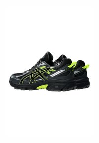 Des chaussures de sport noires et vert fluo avec une tige en maille, une semelle en caoutchouc, un logo bien en vue et des coutures détaillées sur les côtés.