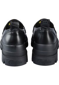 Sorte lær sneakers med en teksturert såle, som har en polstret krage og forsterket hæl, merket logo bak og en trekkstropp for enkel påkledning.