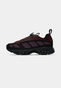 Crne i bordo Nike tenisice s teksturiranim gornjim dijelom, istaknutim ljubičastim detaljima, perforiranim panelima i podstavljenim potplatom s vidljivom zračnoj jedinici.