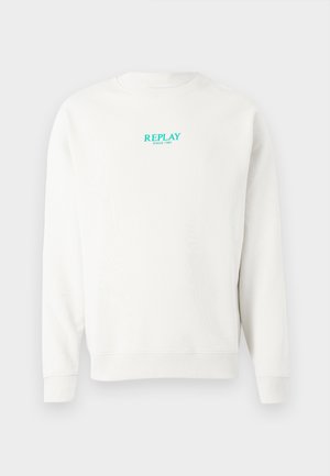 Hvit genser med rund hals laget av myk bomull, med en turkis "REPLAY"-logo og teksten "SINCE 1981" på brystet. Enkel design, lange ermer.