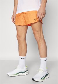 Nike Performance RUN STRIDE - Pantalón corto de deporte - bright mandarin/black