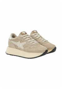 Beige suede sneakers with a white star design, cream laces, and a textured, chunky sole. Fuzzy interior lining for added comfort.