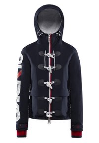 Marinblå jacka med en foder av päls vid huvan, vita toggelknoppar, röd dragkedja och djärv grafisk text på vänster ärm. Strukturerad tyg med detaljer.