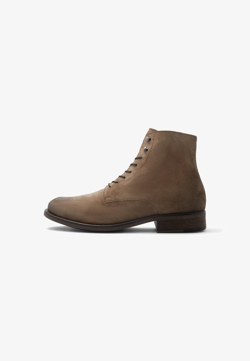 Bottine en daim marron avec lacets sur le devant, bout arrondi et petit talon en bois, vue de profil sur fond blanc.