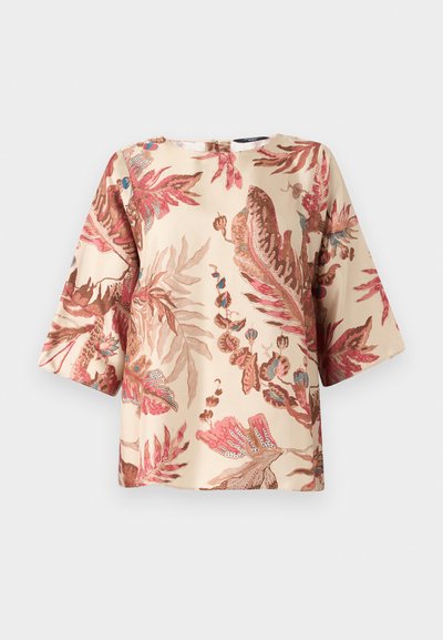 Blomstermønstret bluse i lys beige med rosa og brune bladdesign, korte ærmer og rund halsudskæring med lukning bagpå.