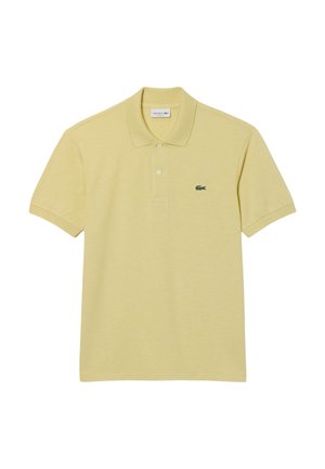 Polo t-shirt i blødt gult bomuld med korte ærmer, tre knapper og et lille grønt Lacoste-logo på venstre bryst. Klassisk kravedesign.