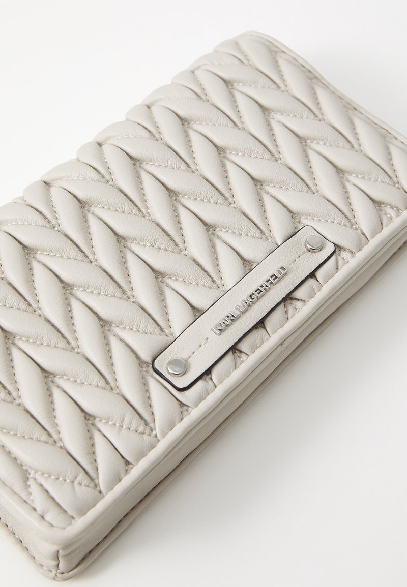 Portafoglio grigio in pelle trapuntata con una texture liscia, dotato di una placca logo in argento e cuciture decorative in un motivo intrecciato.