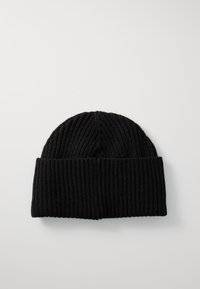 Schwarze Strickmütze mit strukturiertem Rippdesign und umgeschlagenem Bund. Das Material wirkt weich und dehnbar, geeignet für kaltes Wetter.