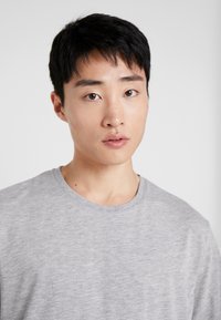 Gray crew-neck t-shirt made of soft fabric, featuring a relaxed fit and short sleeves, shown on a neutral background.