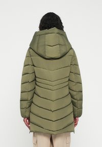 Oliven grønn pufferjakke med hette, med en chevron-quiltet design, elastiske mansjetter og en lengre bakdel for ekstra dekning.