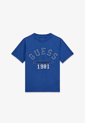 Tricou albastru cu mânecă scurtă, guler nervurat, text "GUESS" deteriorat și "1981" imprimat dedesubt, în centrul din față.