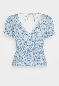 Blouse bleu clair à fleurs, manches courtes, col en V, fermeture par lien au dos, taille froncée et bords de manches à volants.