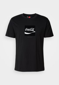 Black cotton t-shirt with short sleeves and round neckline featuring a Coca-Cola logo graphic in white and a rectangular accent.