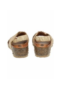 Dos sandalias vistas desde atrás con un upper tejido en beige, detalles de volantes y un tacón texturizado similar a corcho. Plantilla suave con la marca visible.