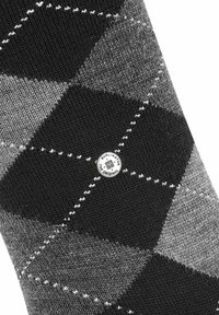 Calcetín con patrón argyle en negro y gris, hecho de un tejido de punto texturizado; presenta un parche de logo redondo con "Burlington" en el centro.