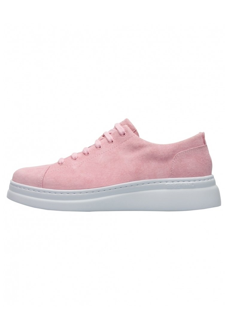 Pink suede sneaker with white rubber sole, rounded toe, and six eyelet lace-up design. Features a smooth texture and simple silhouette.