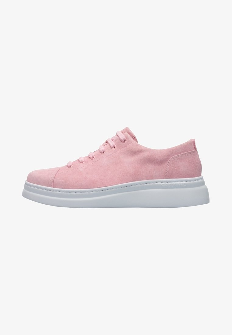 Pink suede sneaker with white rubber sole, rounded toe, and six eyelet lace-up design. Features a smooth texture and simple silhouette.