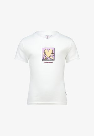 Camiseta blanca de algodón con un gráfico de corazón colorido con patas en un diseño cuadrado, acompañado del texto "Keith Haring" en rojo.