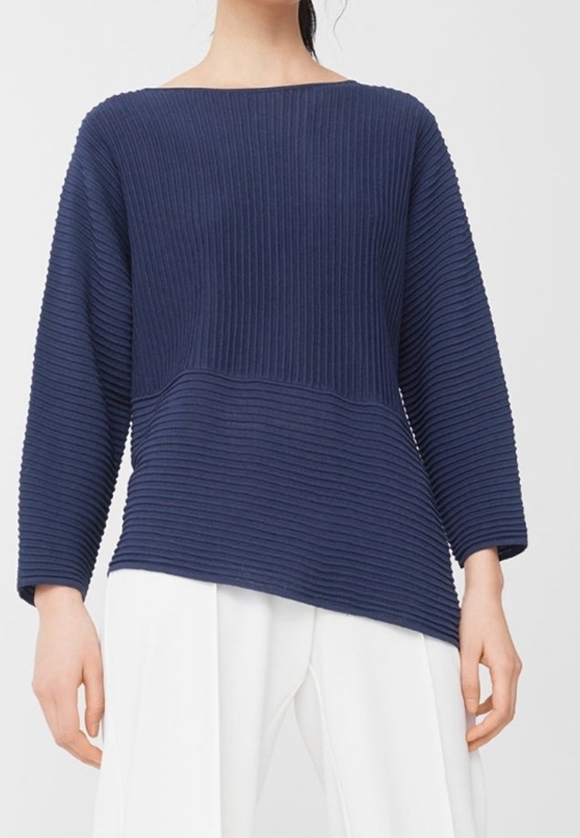 Pull en maille côtelée bleu marine avec un col bateau, des manches longues et un ourlet asymétrique, présentant un tissu texturé et une coupe décontractée.