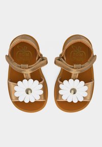 Ζεύγος μεταλλικών χρυσών σανδαλιών για νήπια με διακοσμήσεις λευκού μαργαριταριού και ρυθμιζόμενους ιμάντες αστραγάλου σε λευκό φόντο.